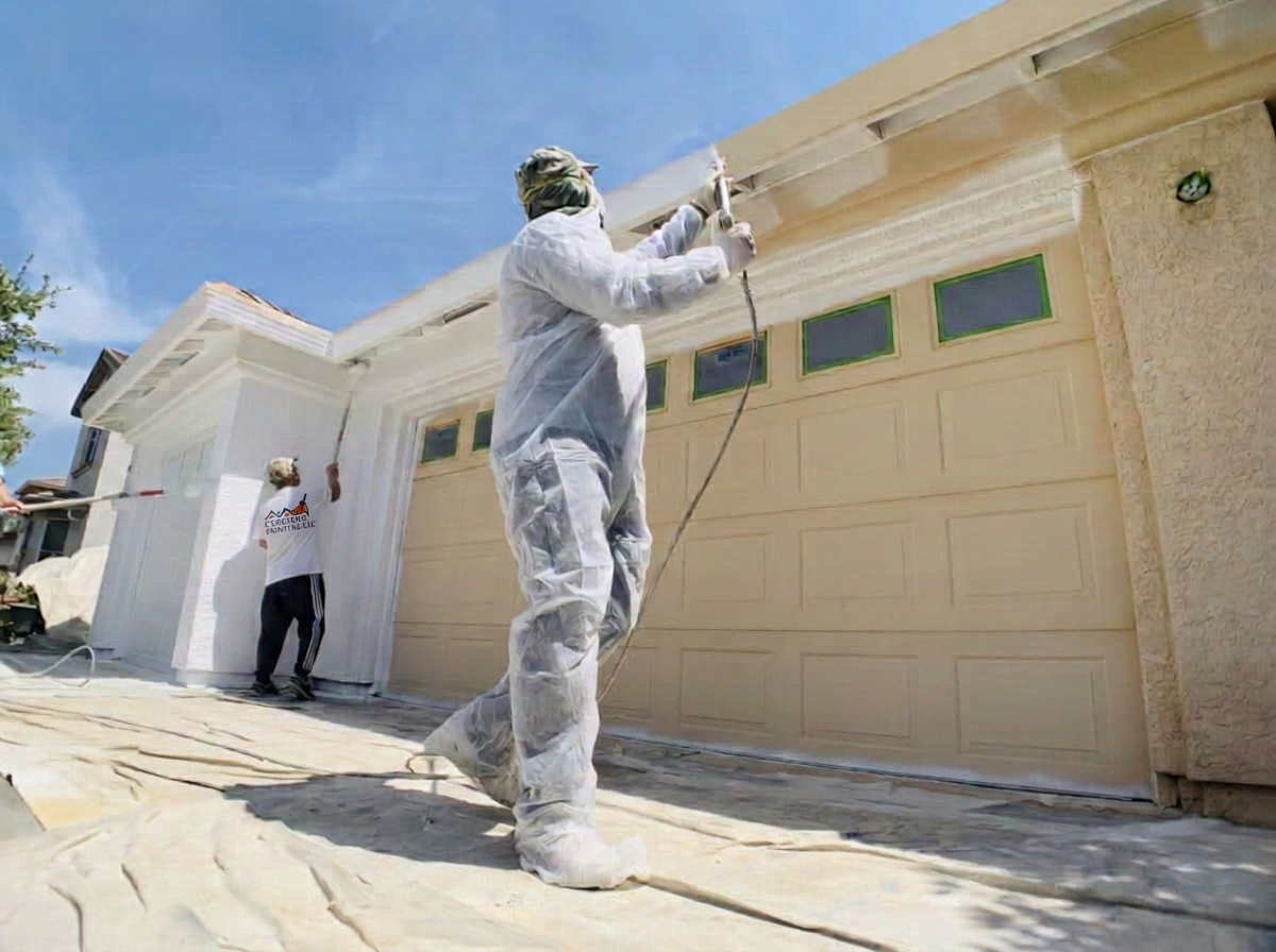 Creativo Painting crew spray-painting a residential exterior in white protective gear